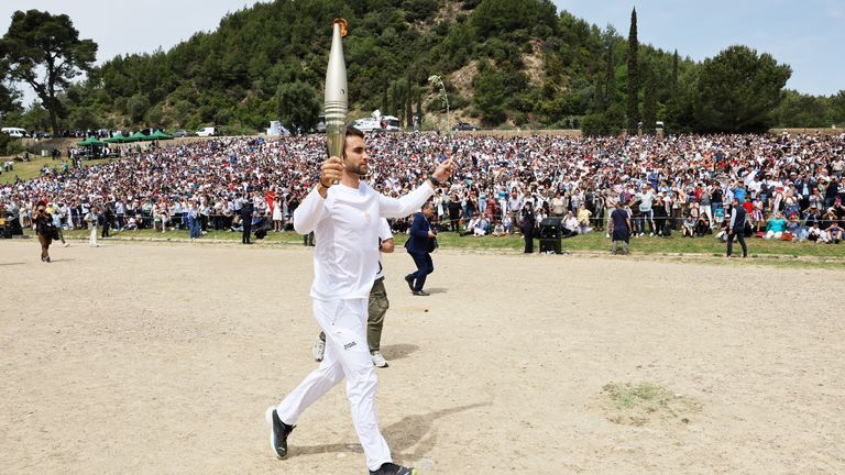 The first torchbearer Greek rower Stefanos Ntouskos, carries the touch during the start of the torch relay after the flame lighting ceremony for the Paris 2024 Olympics.
Pic: Reuters