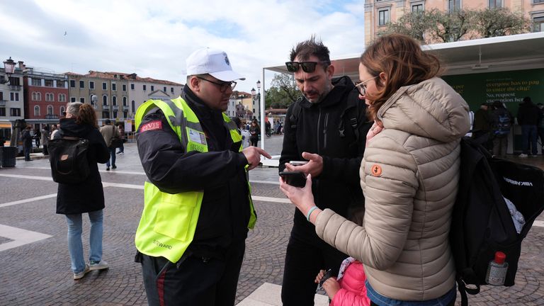 گردشگران برای اثبات پرداخت خود کد QR را روی گوشی هوشمند نشان می دهند.  عکس: رویترز