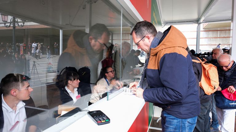 Tourists queue at the information centre to register and receive a QR code. Pic: Reuters