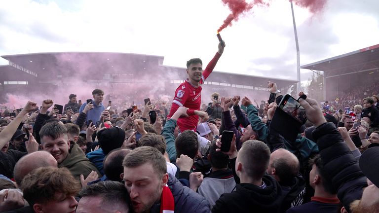 Wrexham fans on the pitch celebrating promotion. Pic: PA