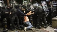 Riot police detain a demonstrator. Pic: AP