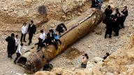 Israelis hang around apparent remains of a ballistic missile after Iran&#39;s attack in April. Pic: Reuters