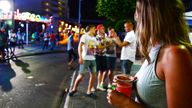 FILE - In this June 10, 2015, file photo, tourists stand on the street in Magaluf, Calvia, on the Spanish Balearic island of Mallorca, Spain. Authorities in Spain's Balearic Islands have ordered on Wednesday, July 15, 2020, the closure of bars and nightclubs in beachfront areas popular with young and foreign visitors in hopes of curbing the spread of the coronavirus and losing a reputation as a place for hard partying. (AP Photo/Joan Llado, File)
