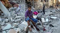 A Palestinian boy sits on debris after an Israeli strike on a house in Rafah on 9 May. Pic: Reuters