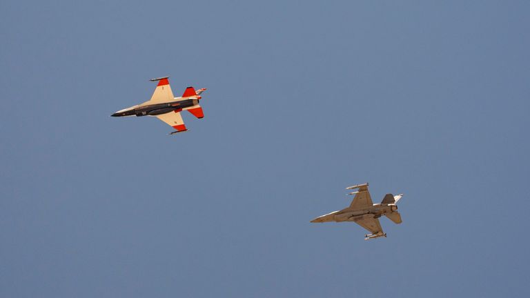 The Air Force's AI-enabled F-16 fighter jet, left, flies next to an opposing F-16