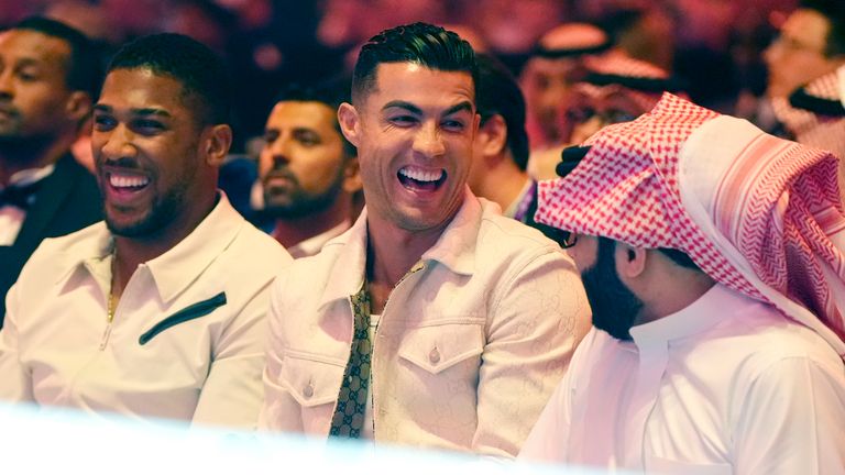Anthony Joshua (left), Cristiano Ronaldo and Saudi adviser Turki Al-Sheikh watch on ringside. Pic: PA