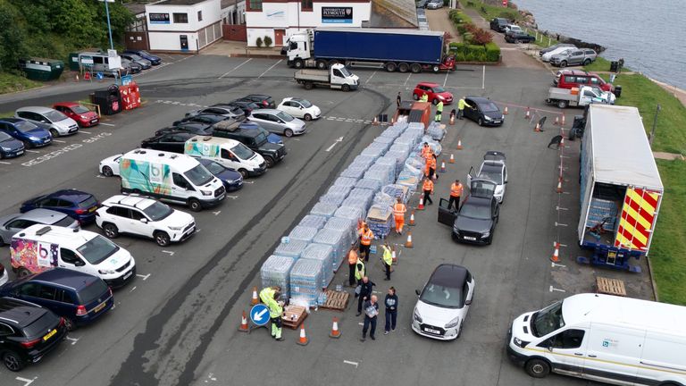 PABest A drone view of people collecting bottled water at Freshwater car park in Brixham. Around 16,000 households and businesses in the Brixham area of Devon have been told not to use their tap water for drinking without boiling and cooling it first, following the discovery of small traces of a parasite in the local water network. Picture date: Friday May 17, 2024.

