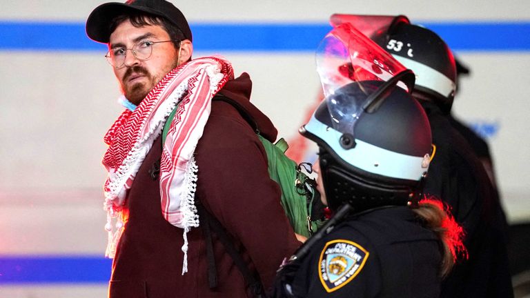 Police detain a protestor, as other police officers enter the campus of Columbia University.
Pic: Reuters