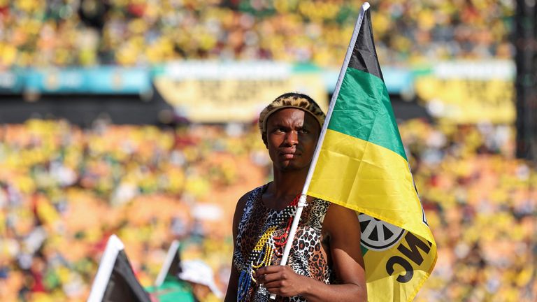 一名支持者举着非洲人国民大会的旗帜。图片来源：路透社