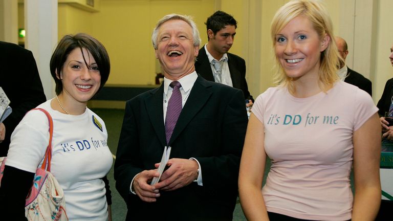 David Davis (C) talks with supporters Donata Huggins (L) and Zoe Aylward at the annual party conference in Blackpool in northern England