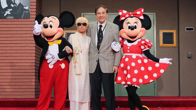 FILE - Mickey Mouse, from left, Elizabeth Gluck, Richard M. Sherman and Minnie Mouse pose for a photo at the ceremony honoring the Sherman Brothers with the rename of Disney Studios Soundstage A at the world premiere of Disney&#39;s "Christopher Robin" at the Walt Disney Studios, July 30, 2018, in Burbank, Calif. Sherman, one half of the prolific, award-winning pair of brothers who helped form millions of childhoods by penning classic Disney tunes, died Saturday, May 25, 2024. He was 95.  (Photo by Willy Sanjuan/Invision/AP, File)