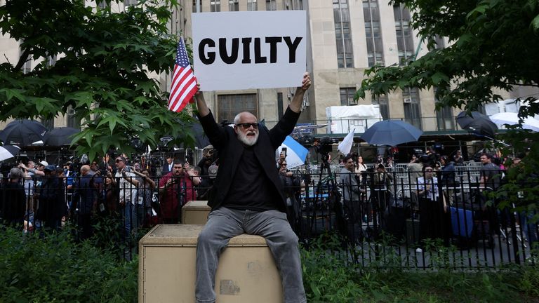 A man holding a placard after Donald Trump was found guilty on all counts in his criminal trial about covering up hush money payments by falsifying business records. Pic: Reuters