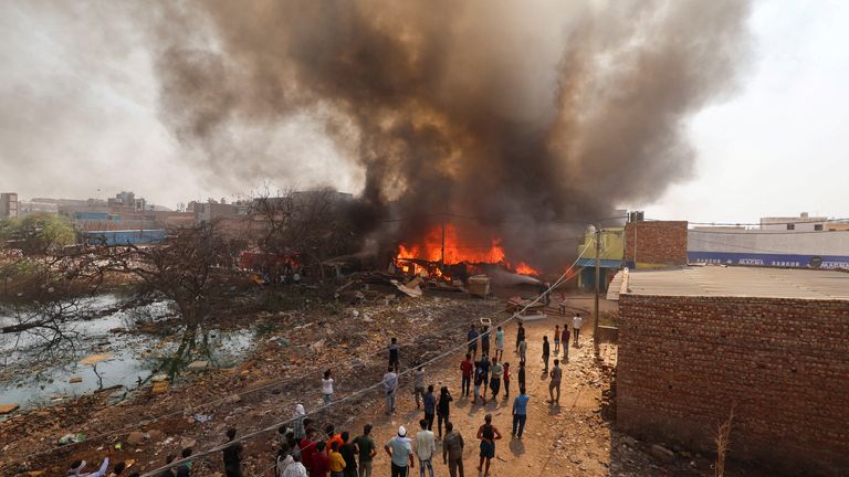 Fire fighters try to douse a fire in a shop near a landfill site in New Delhi earlier this week, as the city grapples with record temperatures. Pic: Reuters