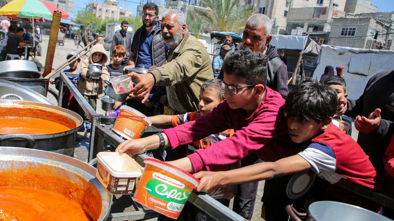 Palestinians wait to receive food cooked by a charity kitchen, in Rafah, in the southern Gaza Strip.
Pic Reuters
