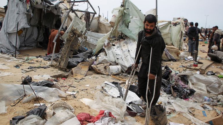 Palestinians survey the devastation after an Israeli strike on a tent camp for displaced people in Rafah. Pic: Reuters