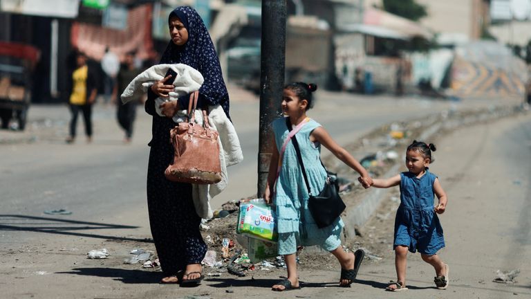 A woman and children flee Rafah after Israel launched a ground and air invasion in the city. Pic: Reuters