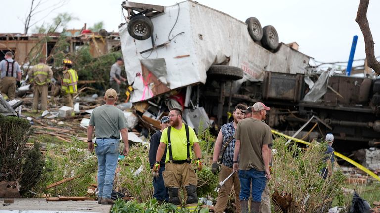 Workers search through the remains of a tornado damaged property, Tuesday, May 21, 2024, in Greenfield, Iowa.  (AP Photo/Charlie Neibergall)