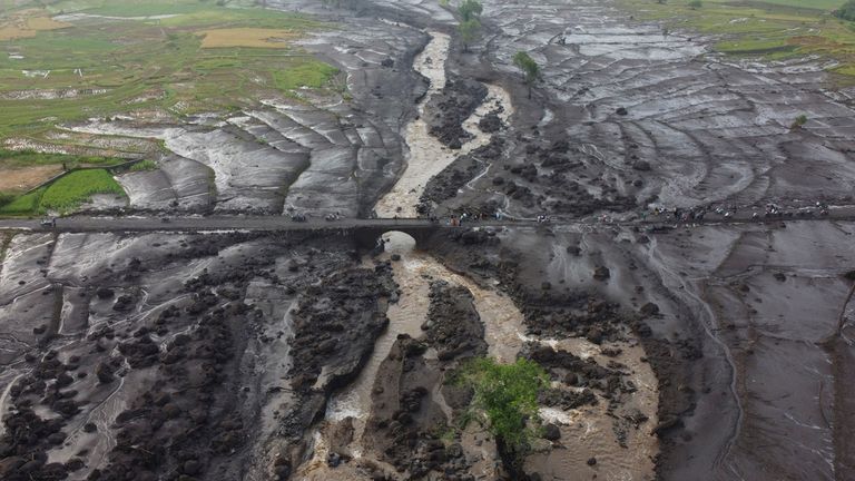 People examine the damage at an area badly affected by a flash flood in Tanah Datar, West Sumatra, Indonesia, Monday, May 13, 2024. Heavy rains and torrents of cold lava and mud flowing down a volcano&#39;s slopes on Indonesia&#39;s Sumatra island triggered flash floods causing a number of people dead and missing, officials said Sunday. (AP Photo/Ali Nayaka)