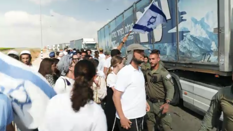 Israelis pictured alongside the aid trucks