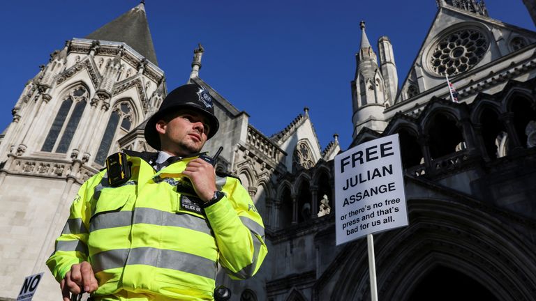 A police officers looks on near a placard outside of the Royal Court of Justice.
Pic: Reuters