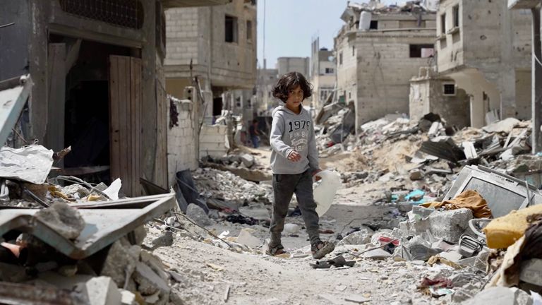 A child walks through the rubble in Khan Younis