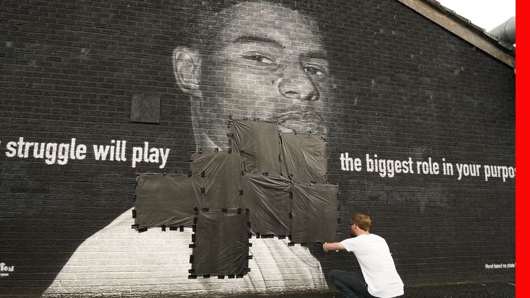 PABest Ed Wellard, from Withington, tapes bin liners across offensive wording on the mural of Manchester United striker and England player Marcus Rashford on the wall of the Coffee House Cafe on Copson Street, Withington, which appeared vandalised the morning after the England football team lost the UEFA Euro 2021 final. Picture date: Monday July 12, 2021.

