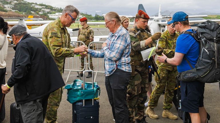 Australian defence force staff members assist Australian and other tourists as they prepare to depart from Magenta Airport in Noumea, New Caledonia. 
Pic: LAC Adam Abela/Royal Australian Airfare/AP