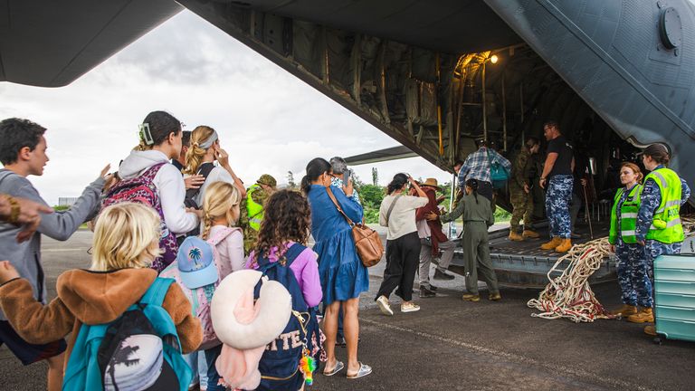 Australian defence force staff members assist Australian and other tourists as they prepare to depart from Magenta Airport in Noumea, New Caledonia. Pic: LAC Adam Abela/Royal Australian Airfare/AP