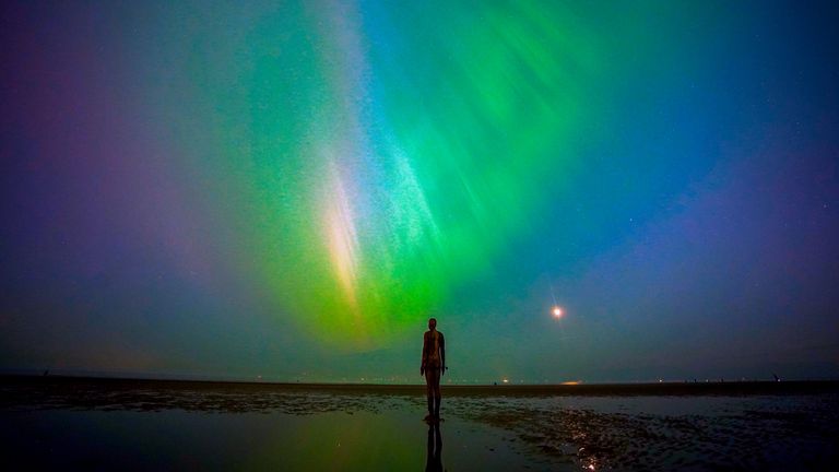 The aurora borealis, also known as the northern lights, glow on the horizon at Another Place by Anthony Gormley, Crosby Beach, Liverpool , Merseyside . Picture date: Friday May 10, 2024. PA Photo. See PA story WEATHER Aurora. Photo credit should read: Peter Byrne/PA Wire