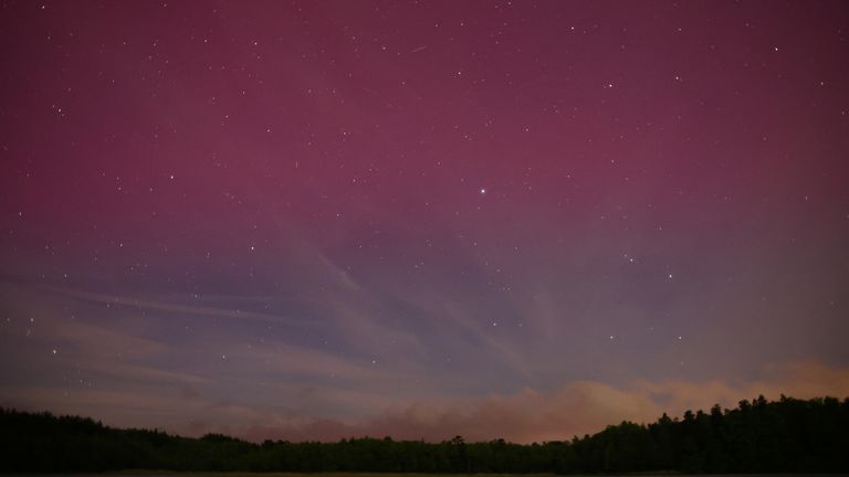 Northern lights are seen over the lake near Szczytno, Poland May 10, 2024. REUTERS/Kacper Pempel