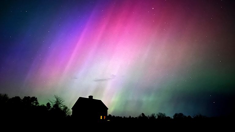 Northern Lights flare in the sky over a farmhouse, late Friday, May 10, 2024, in Brunswick, Maine. (AP Photo/Robert F. Bukaty)