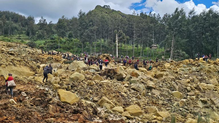People carry bags in the aftermath of a landslide in Enga Province, Papua New Guinea, May 24, 2024, in this still image obtained from a video. Andrew Ruing/Handout via REUTERS THIS IMAGE HAS BEEN SUPPLIED BY A THIRD PARTY. NO RESALES. NO ARCHIVES. MANDATORY CREDIT