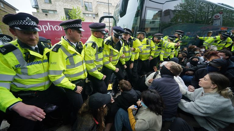 Police with protesters who formed a blockade around a coach which is parked near the Best Western hotel in Peckham.
Pic: PA