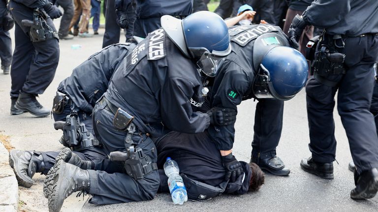Police officers detain an activist during the protest. Pic: Reuters