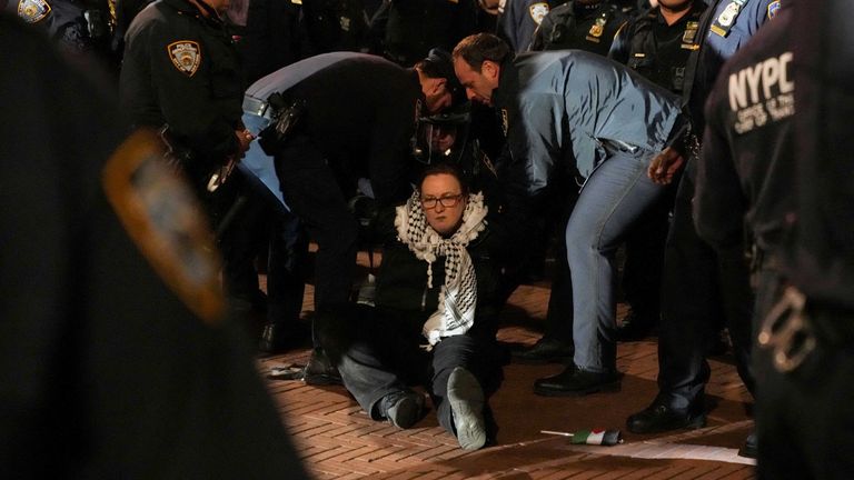 Police detain a protestor, as other police officers enter the campus of Columbia University.
Pic: Reuters