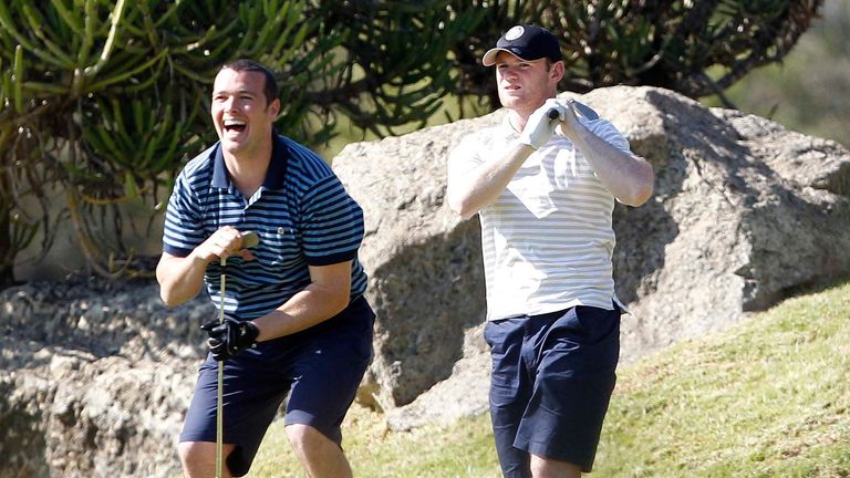 Manchester United masseur Rod Thornley laughs at the tee shot of Wayne Rooney, in South Africa, 2010