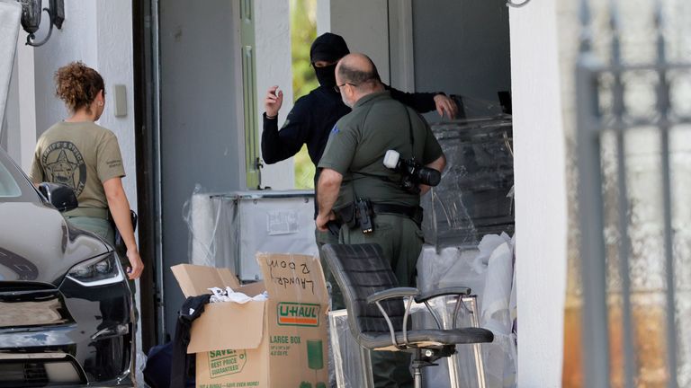 Broward Sheriff's Office personnel move items in the garage of Sean Kingston's home in Southwest Ranches, Florida, on Thursday, May 23, 2024. A SWAT team raided rapper Kingston's rented mansion on Thursday.  and arrested his mother on fraud and theft charges that a lawyer says stemmed in part from installing a huge television in the house.  Broward County detectives arrested Janice Turner, 61, at the home.  (Amy Beth Bennett/South Florida Sun-Sentinel via AP)