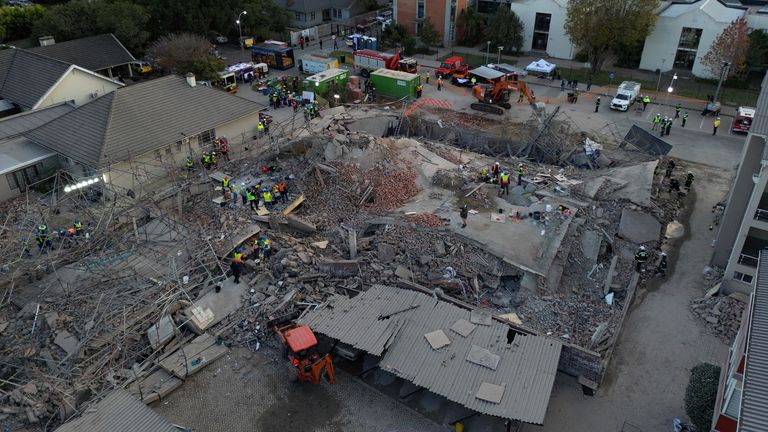 Rescuers use an excavator at the site where construction workers are trapped under a building that collapsed in George, South Africa May 7, 2024. REUTERS/Esa Alexander