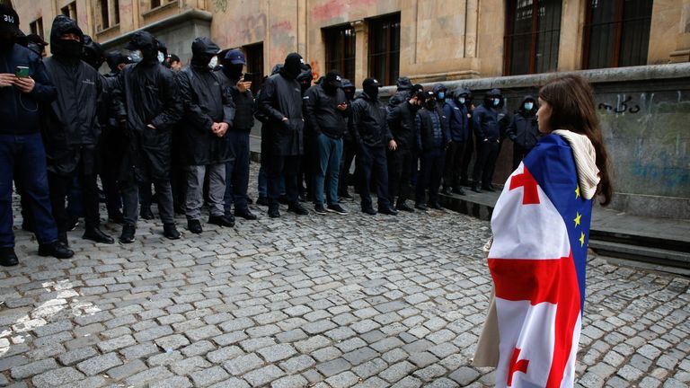 A protester wearing a Georgian and European flag faces off policemen blocking a street during a rally against the &#39;foreign bill&#39;. Pic: David Mdzinarishvili/EPA-EFE/Shutterstock