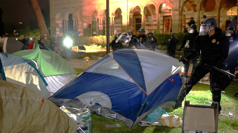 Law enforcement officials try to move a tent at the protest encampment at UCLA