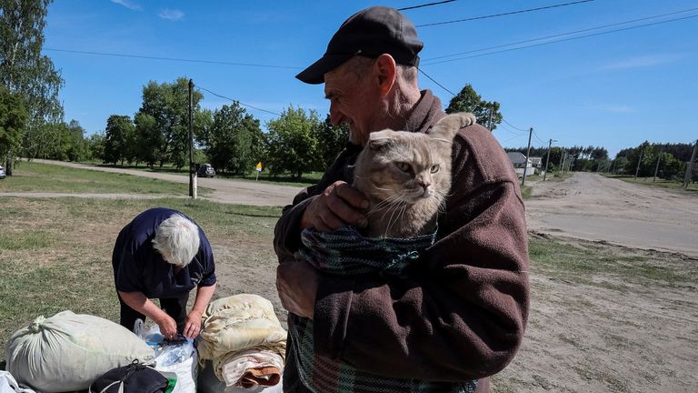 A man holds a cat as residents from Vovchansk and nearby villages wait for buses amid an evacuation to Kharkiv due to Russian shelling, amid Russia&#39;s attack on Ukraine, at an undisclosed location near the town of Vovchansk in Kharkiv region, Ukraine May 10, 2024. REUTERS/Vyacheslav Madiyevskyy
