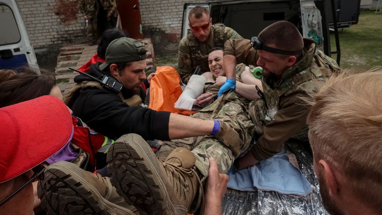 Medical workers and servicemen treat a wounded Ukrainian service membe near the town of Vovchansk in Kharkiv. Pic: Reuters 