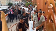Palestinians carrying bodies of the dead following the attack. Pic: AP