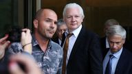 Julian Assange, middle, leaves the court in Saipan. Pic: Reuters