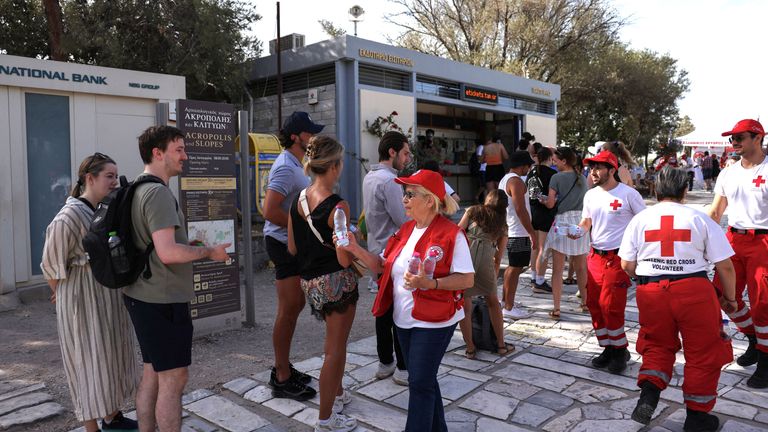 Members of the Hellenic Red Cross hand over bottles of water to tourists who line up to visit the Acropolis hill archaeological site.
Pic:Reuters