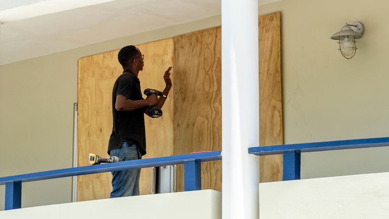 A man boards up a door in preparation for Hurricane Beryl. Pic: AP