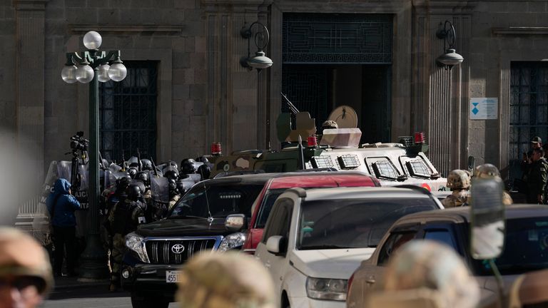 Military Police gather outside the main entrance as an armoured vehicle rams into the door of the presidential palace. Pic: AP