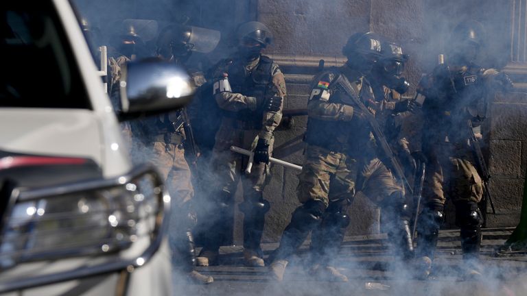 Military police stand amid tear gas outside the presidential palace. Pic: AP