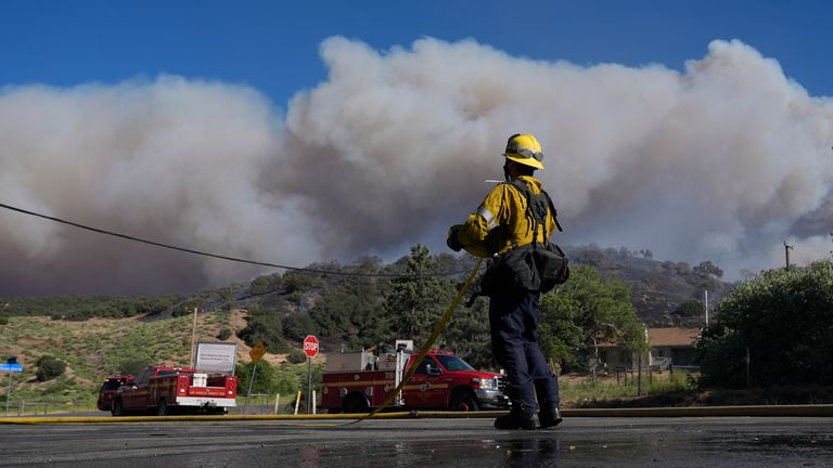A firefighter watches a plume of smoke from the Post Fire  in California.
Pic: AP