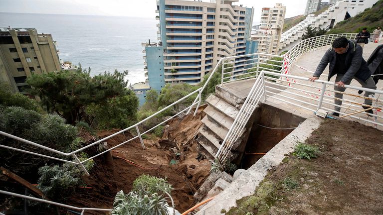 People stand at a building complex, near a landslide after heavy rains hit Vina del Mar, Chile.
Pic: Reuters